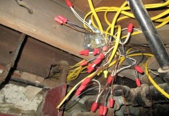 Tangled improvised electrical wiring joined with numerous wire connectors