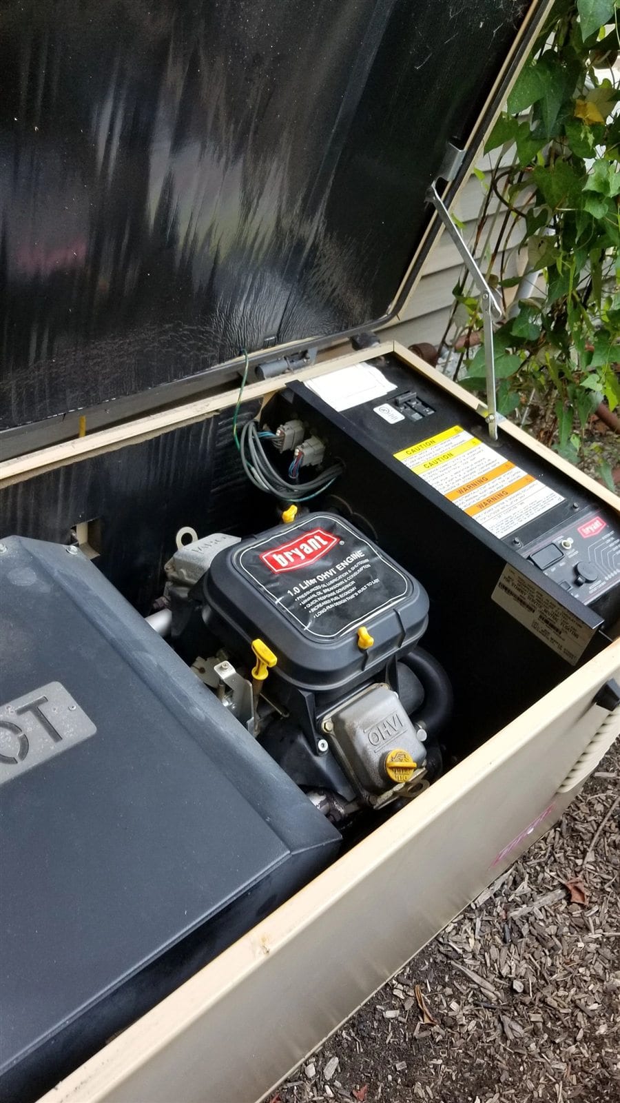 Whole-house standby generator opened for engine and electrical maintenance