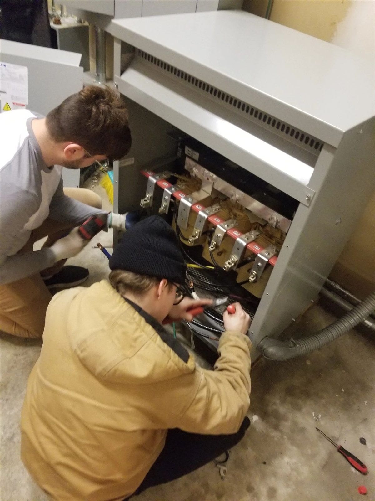 Apprentices receiving hands-on commercial transformer installation training